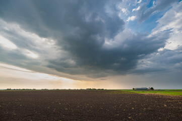 Storm cloud over the plain wide open Dutch landscape at sunset