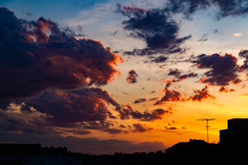 A stunning display of dramatic clouds illuminated by the vibrant colors of a sunset, showcasing the beauty and complexity of nature's evening skies. Perfect for backgrounds and atmospheric scenes.