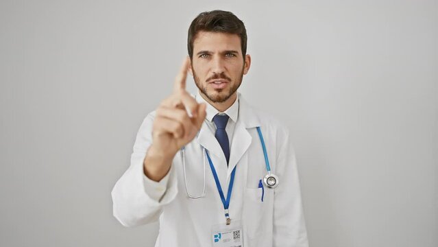 Young, furious hispanic man, portrait of an angry doctor pointing accusingly at you, camera capturing his wrath; isolated on stark white background.