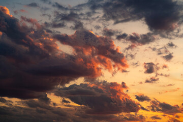A stunning display of dramatic clouds illuminated by the vibrant colors of a sunset, showcasing the beauty and complexity of nature's evening skies. Perfect for backgrounds and atmospheric scenes.