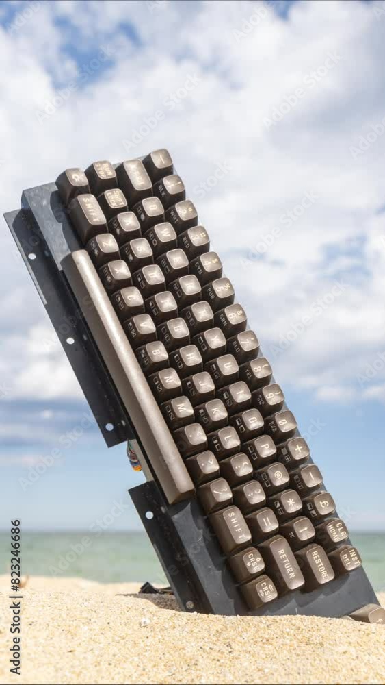 Poster retro keyboard stick on beach in vertical