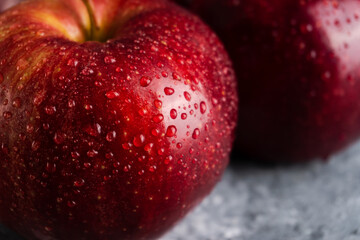 Wet and juicy fresh red apples with water drops on dark background. Selective focus. Macro