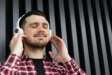 Attractive young guy listens to music in headphones