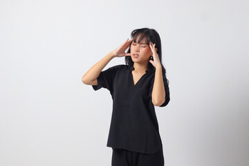 Portrait of overwhelmed Asian woman in casual shirt touching her head, having headache, and feeling...