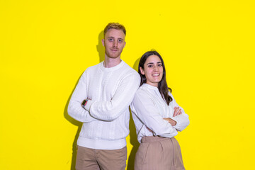 A man and a woman are standing next to each other on a yellow background