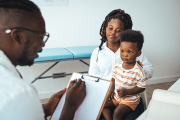 African male pediatrician hold stethoscope exam child boy patient visit doctor with mother, black...