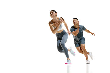 Man and woman wearing sports clothes mid-stride during sprinting exercise against white studio...