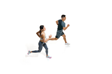Fototapeta premium View from above woman and man running with powerful strides, showcasing their athletic strength against white studio background. Concept of people in sport, healthy lifestyle, teamwork, motivation. Ad