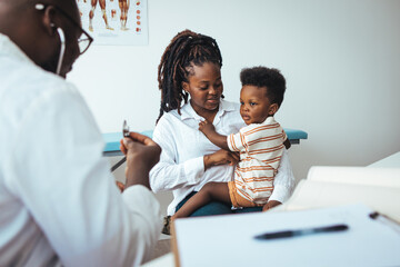 African male pediatrician hold stethoscope exam child boy patient visit doctor with mother, black...