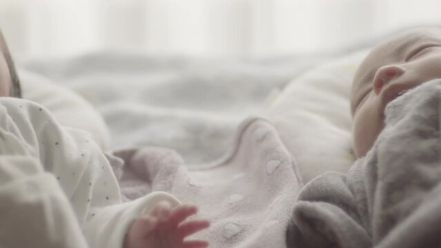 Closeup of a hand moving next to a sleeping newborn