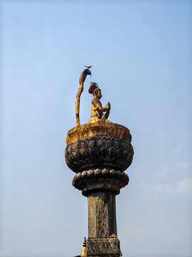Statue of King Yoga Narendra Malla on a stone pillar at historical site in Lalitpur. Nepal