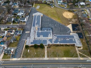 Aerial view of a school building with solar panels on a cloudy day on Long Island, New York.