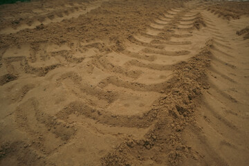 Machine Imprints in sand soil. Truck work machine wheel tracks in the sand