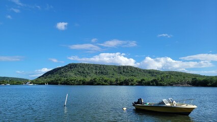 Small boat on a picturesque shoreline, with a backdrop of green mountains