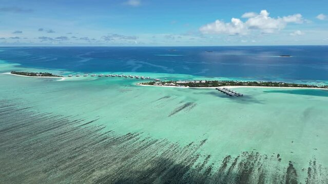Drone view of a beautiful scenery of a blue and green sea water with cloudy sky