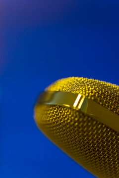 Extreme close up of a gold microphone
