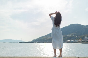 海ではしゃいでいる白いワンピースの女性