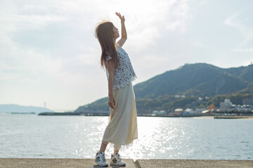 海でたそがれている髪長い女性