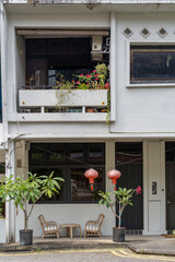 an old chinese house with flower pots outside and red lanterns