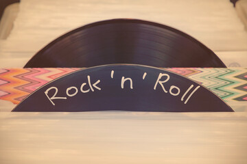 Retro styled image of vinyl turntable records on a flea market with the text rock and roll written...