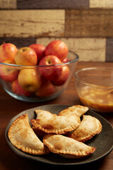 Wooden table with fried apple pastries
