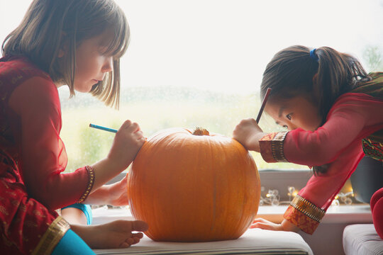 Young Girls Making a Pumpkin Lantern
