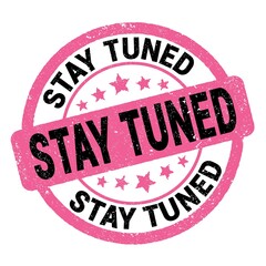 STAY TUNED text written on pink-black round stamp sign.