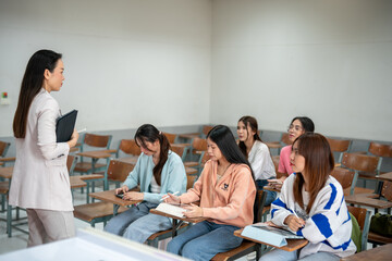 A teacher is standing in front of a group of students in a classroom