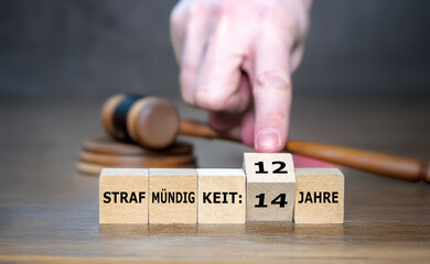 Hand dreht Würfel und ändert den Ausdruck 'Strafmündigkeit 14 Jahre' zu 'Strafmündigkeit 12...