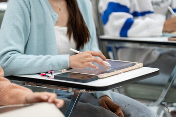 A woman is using a tablet in a classroom