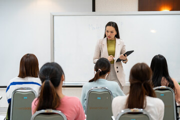 A woman is teaching a group of women in a classroom