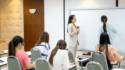 A woman is teaching a class of students in a classroom