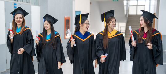 A group of women in graduation gowns are walking down a hallway