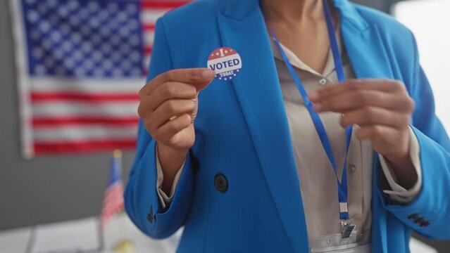 American woman with badge in blazer over usa flag backdrop in a voting concept portrait