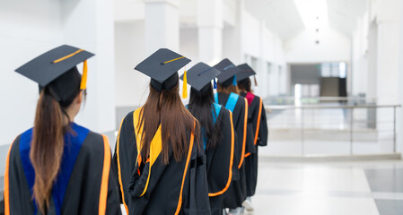 A group of women in graduation gowns are walking down a hallway