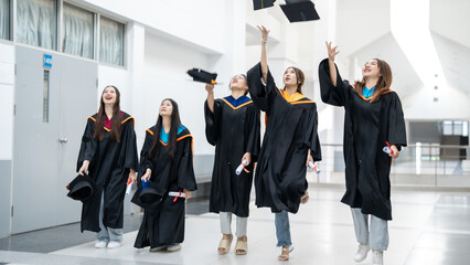 A group of women in graduation gowns are celebrating their achievements by throw
