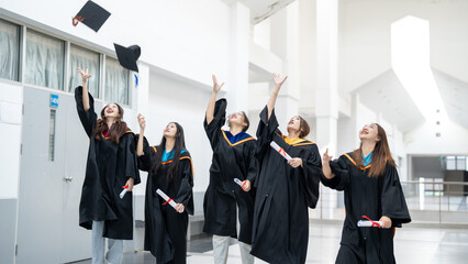 A group of women in graduation gowns are celebrating their achievements by throw