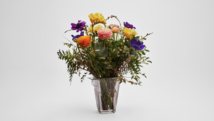 Beautiful multicolored flower bouquet in vase on white background
