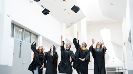 A group of women in graduation gowns are celebrating their achievements by throw