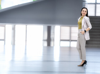 A woman in a business suit stands in a hallway
