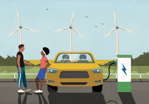 Young couple talking while waiting for electric car to charge at rural charging station
