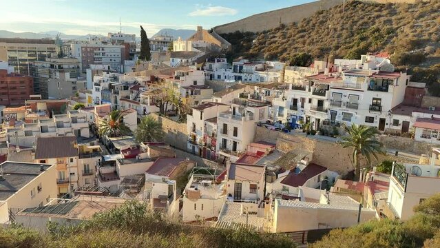Drone shot of an old Alicante town placed on a mountain foot in Spain below the Santa Barbara castle