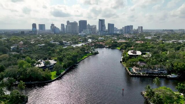 aerial pullout fort lauderdale skyline in background with luxury homes in foreground along waterway