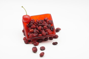 Red bowl overflowing with Rosehip on a white background