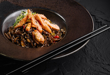 Asian stir-fry chicken with noodles on elegant plate