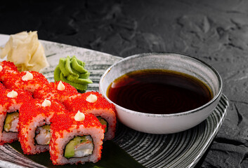 Spicy california roll with tobiko on dark slate