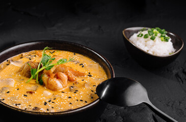 Creamy shrimp curry with rice on dark table