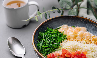 Fresh poke bowl with tea on grey background