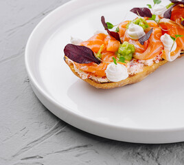 Gourmet smoked salmon bruschetta on white plate