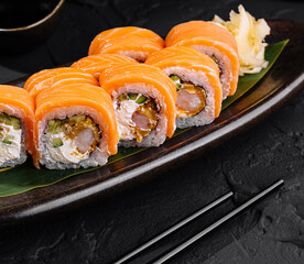 Fresh salmon sushi rolls on elegant plate with chopsticks